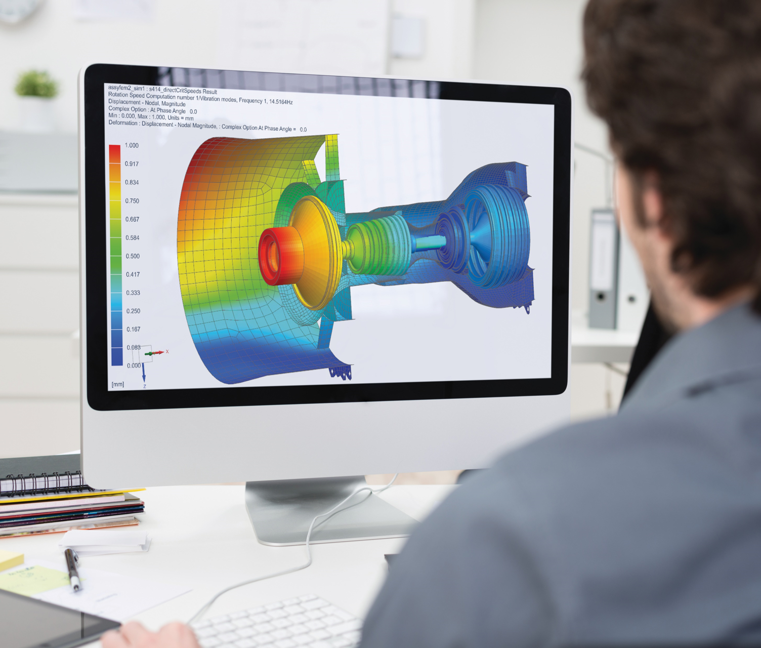 Photo of a person working at a desktop computer. They have Simcenter 3D software pulled up.