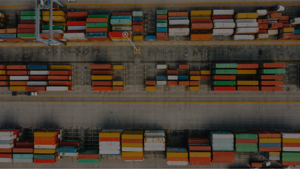 A dock with crates loaded on top of each other. Siemens Opcenter APS specializes in various industries including export/import.